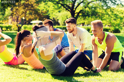 Image of group of friends or sportsmen exercising outdoors