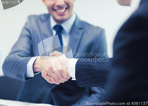 Image of two businessmen shaking hands in office