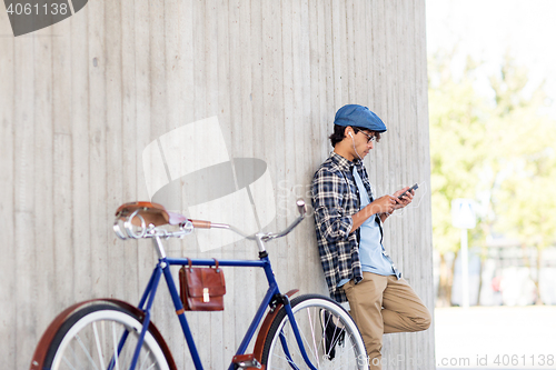 Image of man with smartphone, earphones and bicycle