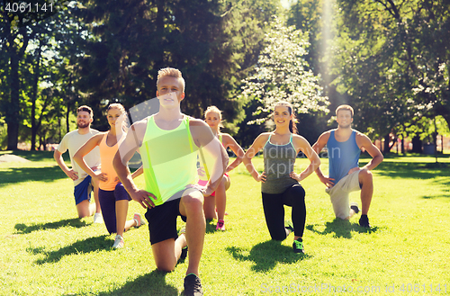 Image of group of friends or sportsmen exercising outdoors