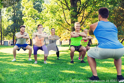 Image of group of friends or sportsmen exercising outdoors