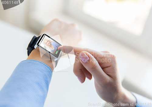 Image of close up of hands with incoming call on smartwatch