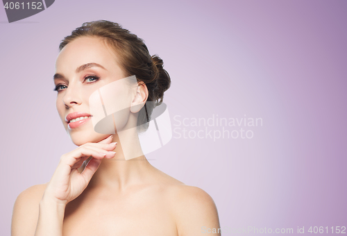 Image of beautiful young woman touching her face