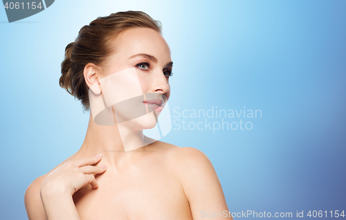 Image of beautiful young woman touching her neck