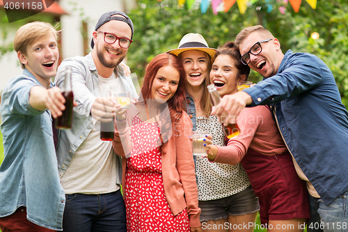 Image of happy friends with drinks at summer garden party
