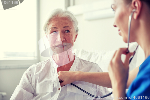 Image of nurse with stethoscope and senior woman at clinic