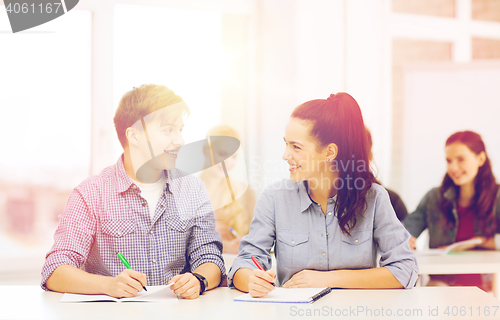 Image of two teenagers with notebooks at school