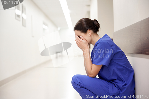 Image of sad or crying female nurse at hospital corridor