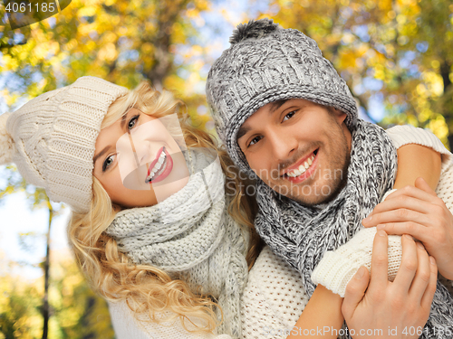 Image of happy couple in warm clothes over autumn