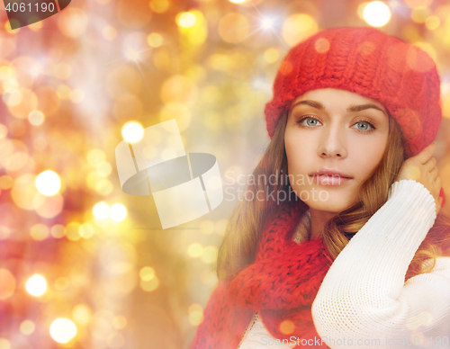 Image of happy woman in hat, scarf and pullover over lights