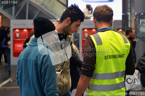 Image of Striking Norwegian train driver assisting travelers