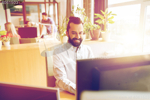 Image of happy creative male office worker with computer