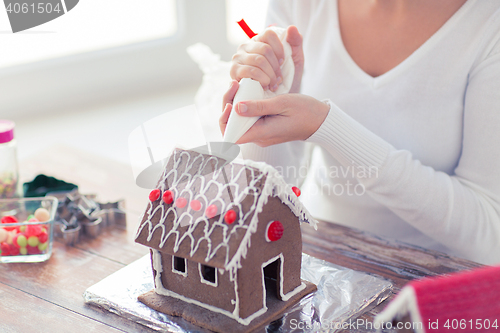 Image of close up of woman making gingerbread house at home