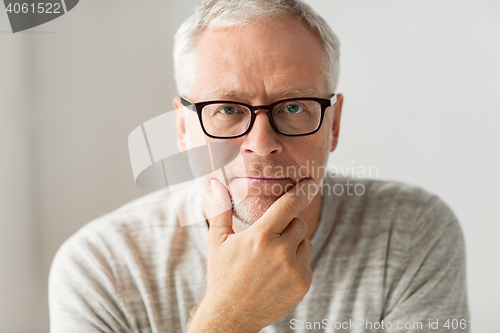 Image of close up of senior man in glasses thinking