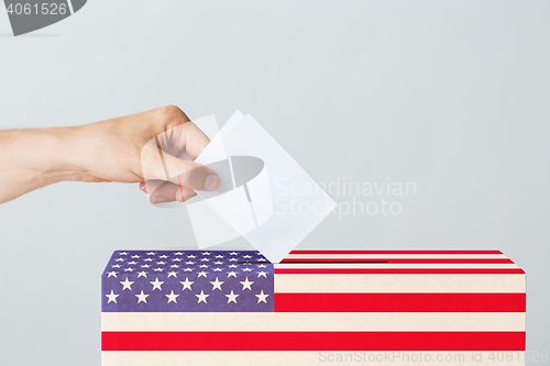 Image of man putting his vote into ballot box on election