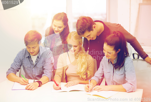 Image of smiling students with notebooks at school