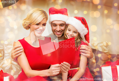 Image of smiling family reading postcard