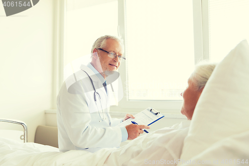 Image of senior woman and doctor with clipboard at hospital