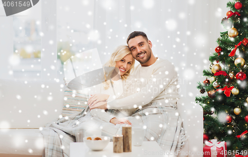 Image of happy couple at home with christmas tree