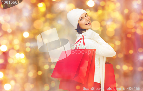 Image of happy woman in winter clothes with shopping bags