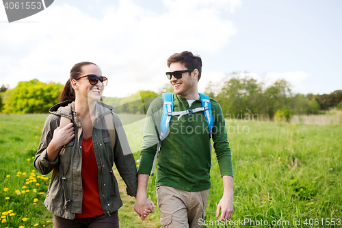 Image of happy couple with backpacks hiking outdoors