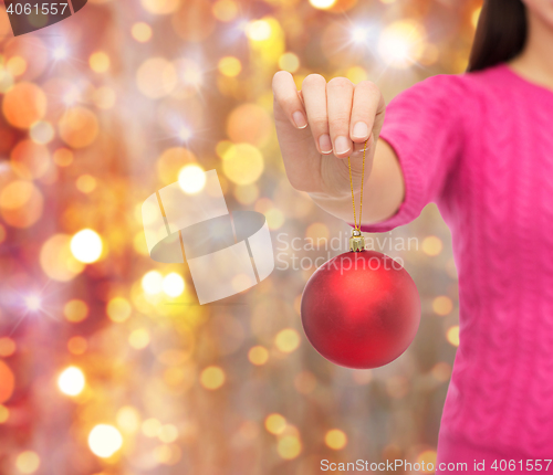 Image of close up of woman in sweater with christmas ball