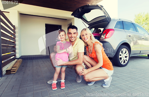 Image of happy family with hatchback car at home parking