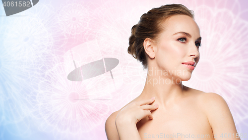 Image of beautiful young woman touching her neck