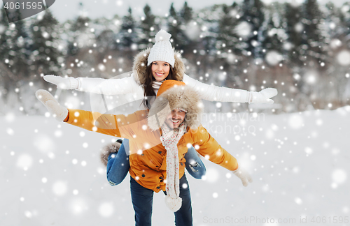 Image of happy couple having fun over winter background