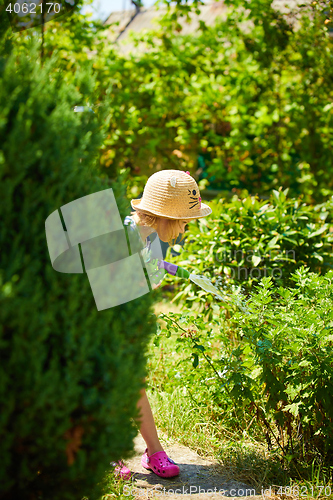 Image of Little happy girl watering garden