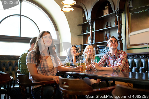 Image of friends with beer watching football at bar or pub