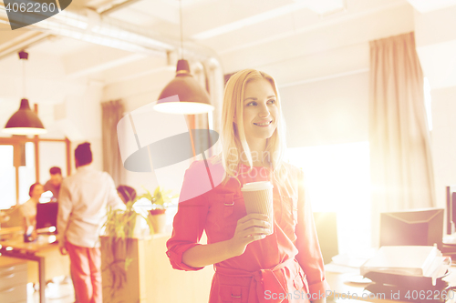 Image of happy creative female office worker with coffe cup