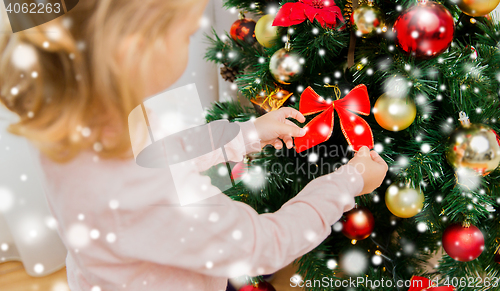 Image of close up of little girl decorating christmas tree