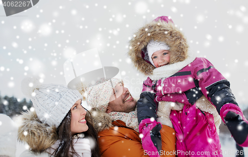 Image of happy family with child in winter clothes outdoors