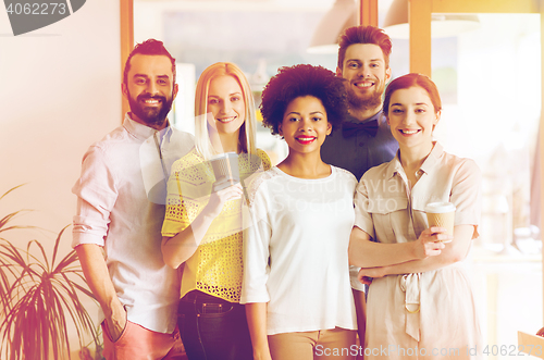 Image of happy smiling creative team with coffee in office