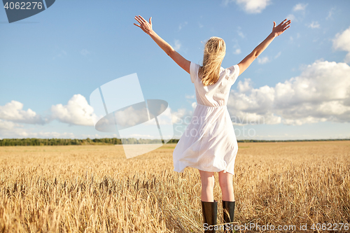 Image of happy young woman in white dress on cereal field