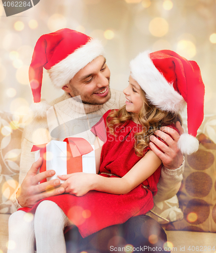 Image of smiling father and daughter holding gift box