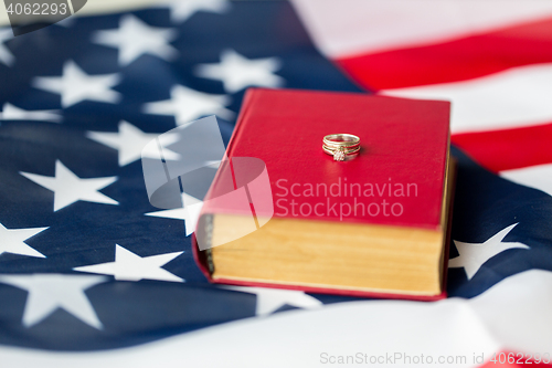 Image of close up of american flag, wedding rings and bible