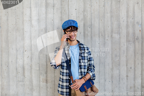 Image of man with bag calling on smartphone at street wall