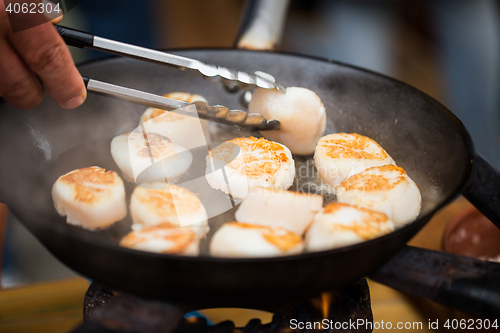 Image of close up of scallops frying in cast iron pan