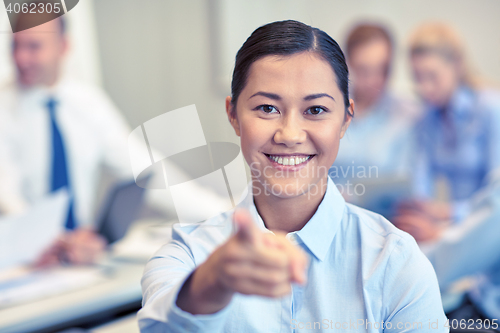Image of group of smiling businesspeople meeting in office