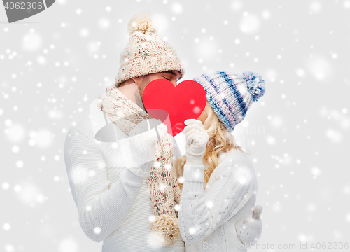 Image of smiling couple in winter clothes with red heart