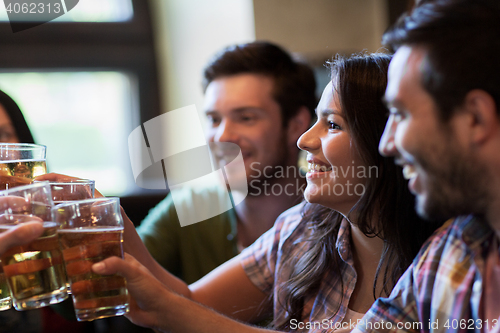 Image of happy friends drinking beer at bar or pub