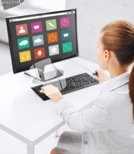 Image of businesswoman with menu icons on office computer
