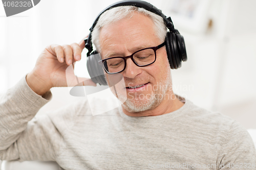 Image of happy man in headphones listening to music at home