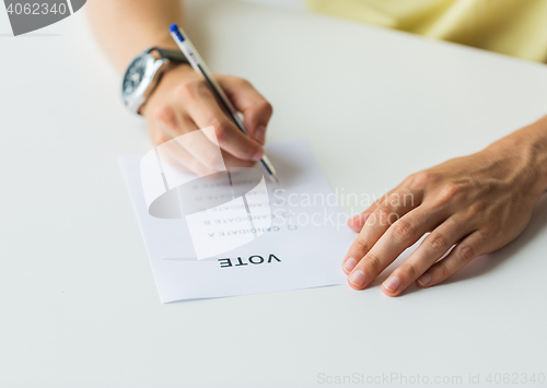 Image of close up of hands with vote or ballot on election