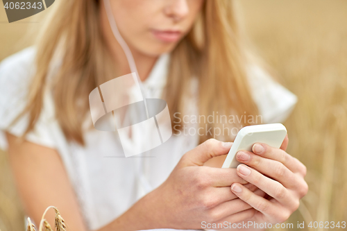 Image of close up of woman with smartphone and earphones