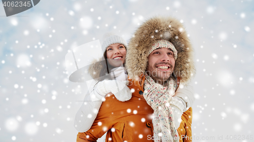 Image of happy couple having fun over winter background