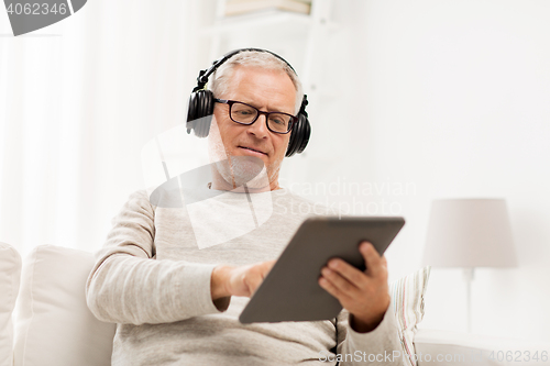 Image of senior man with tablet pc and headphones at home