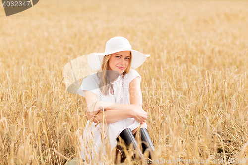 Image of happy young woman in sun hat on cereal field